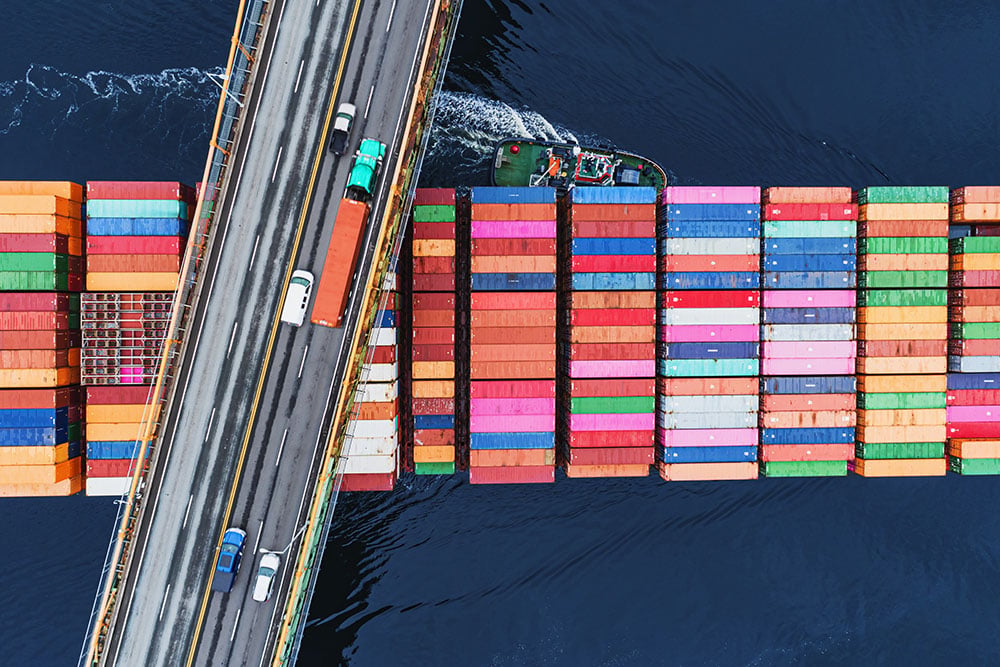 A container ship in port, set against a backdrop of infrastructure, symbolising global merchant fleets and energy supply 
