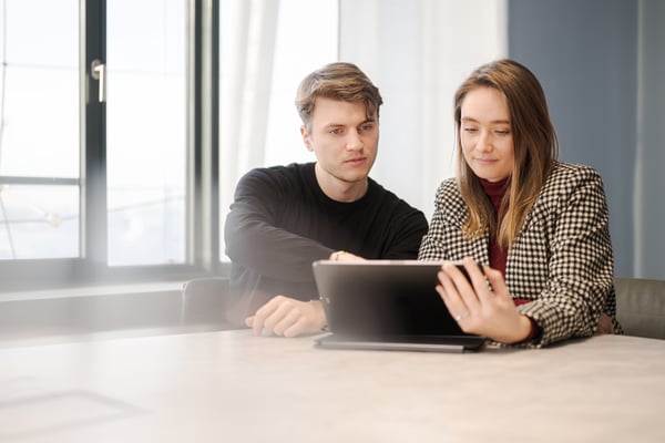 Mann und Frau füllen am Computer ein Formular aus