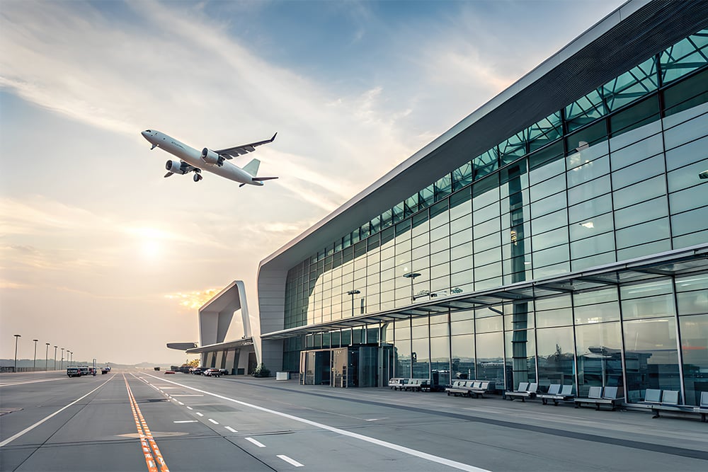 Startendes Flugzeug vor dem Flughafengebäude