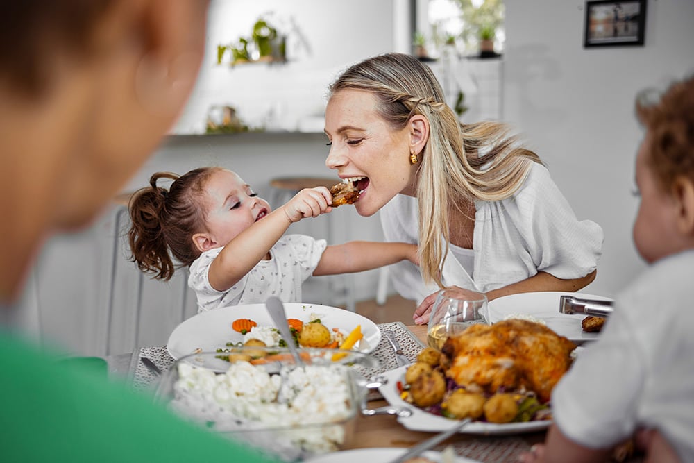 Familie am Esstisch in Einfamilienhaus mit Wärmeversorgung im Fokus