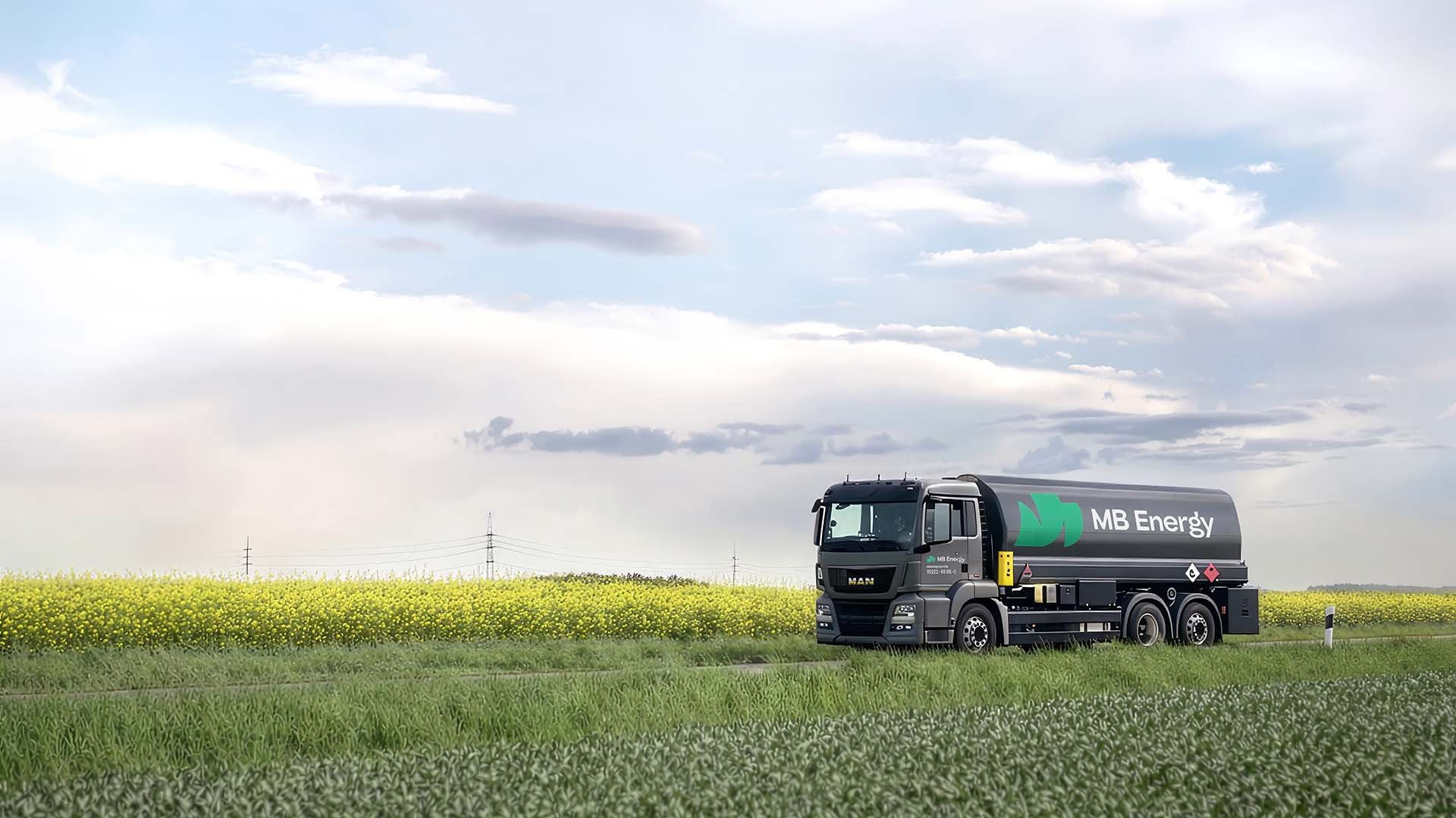 Tanklastwagen von MB Energy auf Landstraße im Grünen