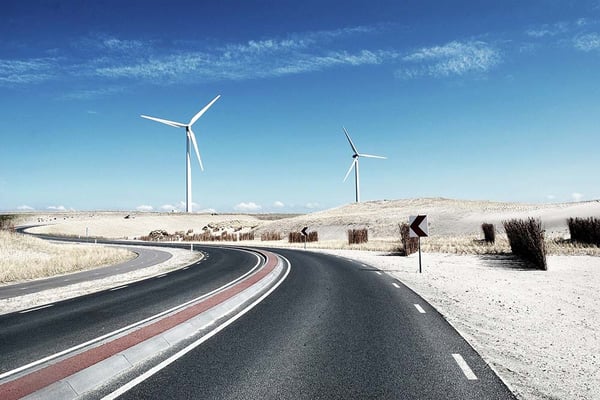Straße mit Windrädern im Hintergrund