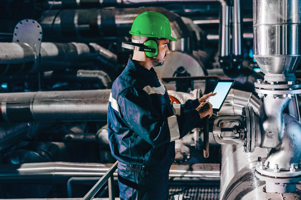 Man with helmet and tablet in supply room