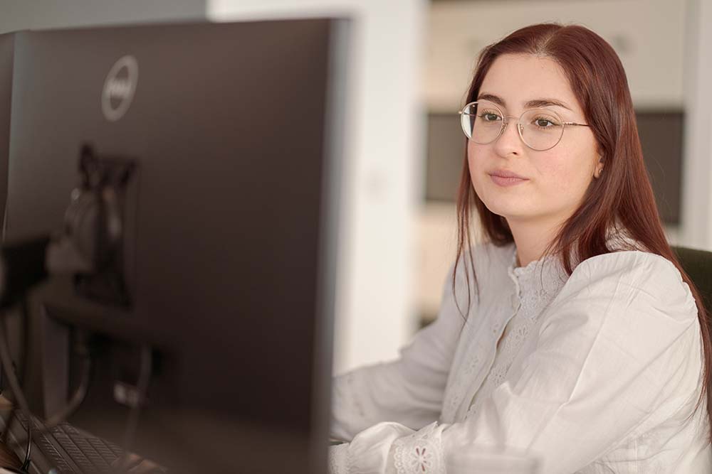 Mitarbeiterin bearbeitet Heizölbestellung am Computerarbeitsplatz