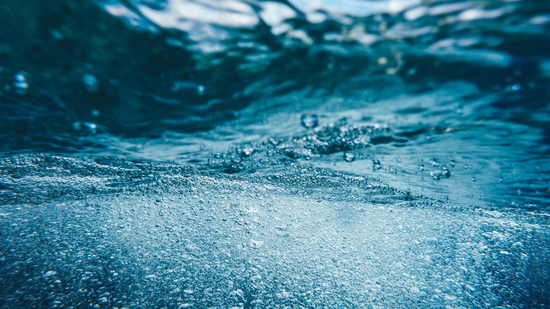 Luftblasen unter Wasser als Symbol für grünen Wasserstoff und emissionsfreie Energie